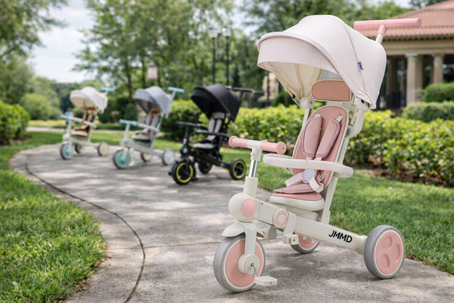 JMMD A7 7-in-1 growth tricycle shown in a multi-color outdoor scene with pink, mint, gray, and black options