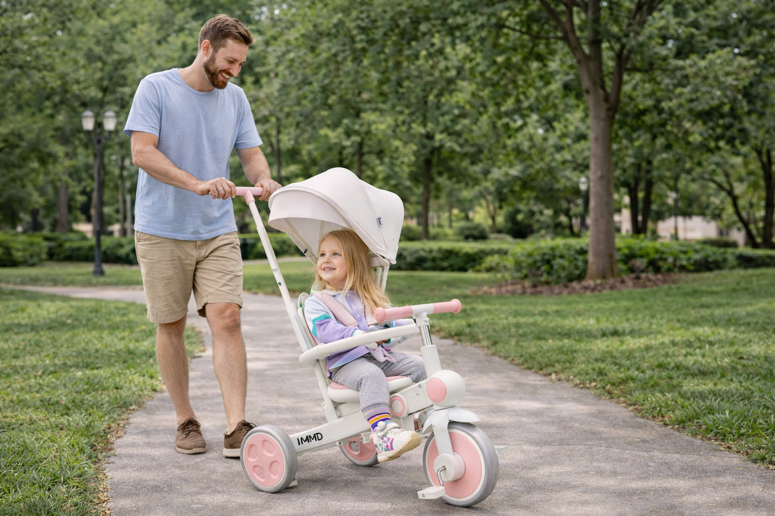 Father pushing JMMD A7 toddler tricycle with child in outdoor park