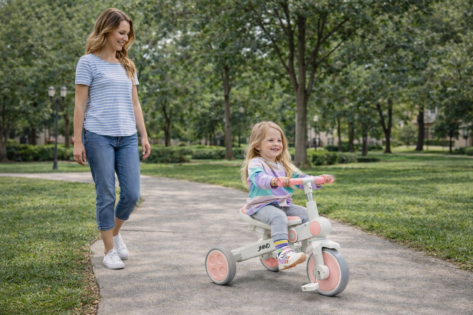 Toddler riding JMMD A7 tricycle while mom walks alongside in park