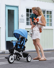 #color_all Mother holding child beside the JMMD b31 blue tricycle outdoors