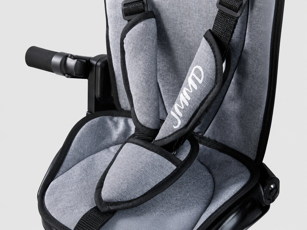 Close-up of the JMMD B56 padded seat and safety harness in gray fabric
