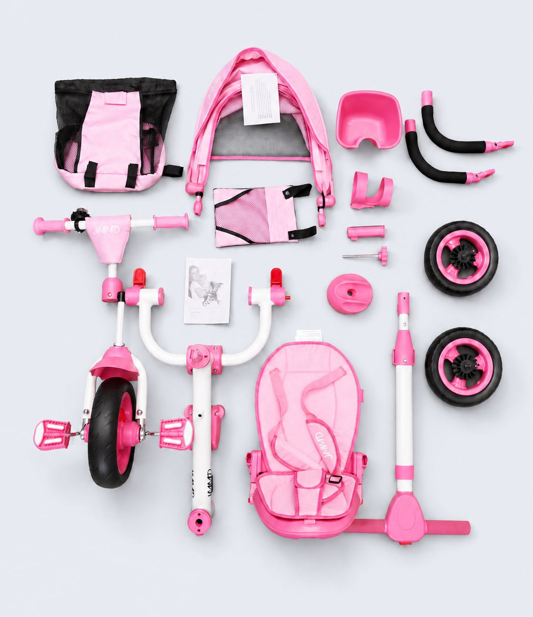 JMMD B56 pink kids trike parts and accessories arranged on a light blue studio background