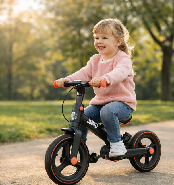 Toddler girl riding JMMD balance bike in park, designed for comfort and early riding confidence