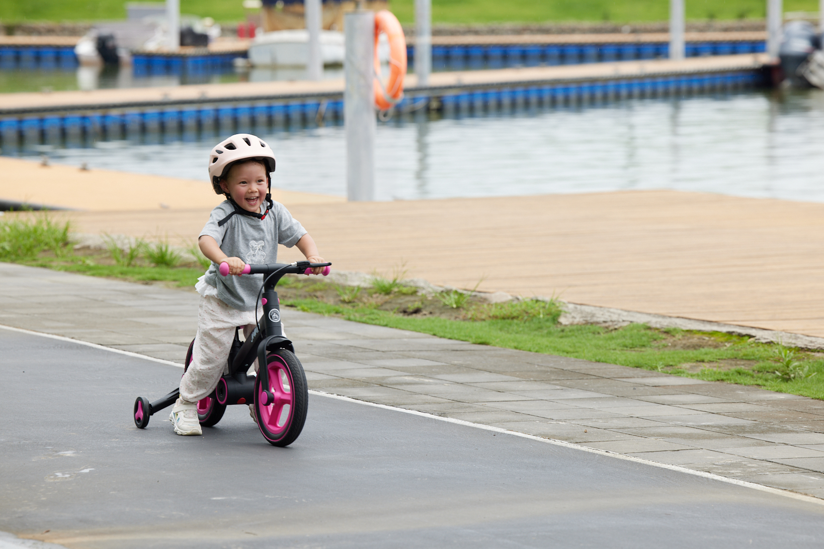 Happy child riding a JMMD S900 kids bike outdoors by the lakeside
