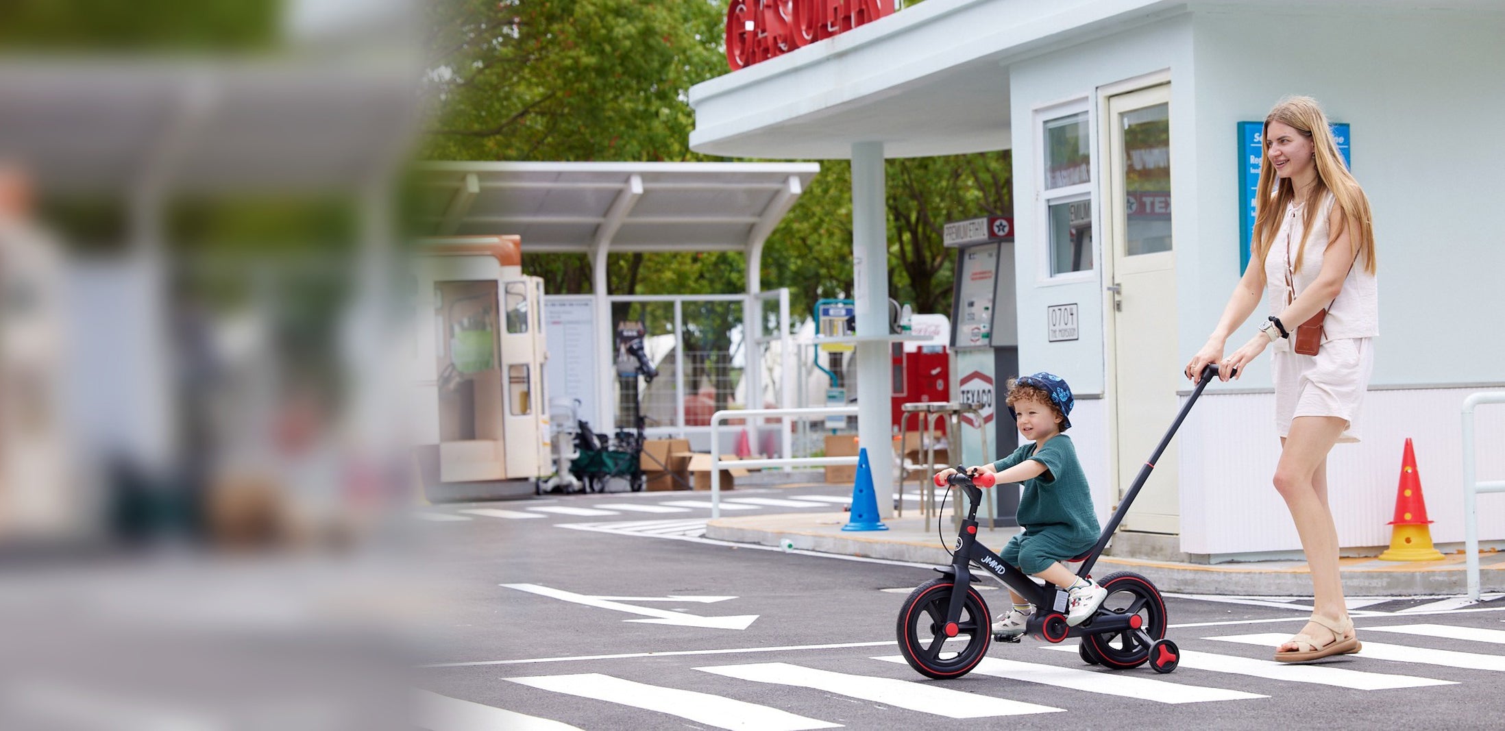 Child riding the JMMD S900 kids bike with parent handle on an outdoor play road