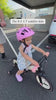 Toddler girl riding the JMMD S900 Grow-With-Me Bike outdoors with parent push handle