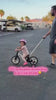 Toddler girl riding the JMMD S900 Grow-With-Me Bike with parent push handle outdoors