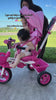 Toddler using the soft pink JMMD B31 Starter Trike outdoors with parent assistance