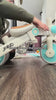Baby riding the JMMD A7 Folding Trike indoors with parent push handle assistance